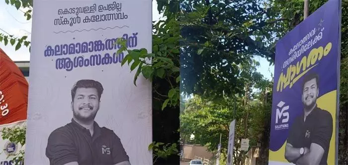 കലോത്സവത്തിനെത്തുന്ന വിദ്യാര്‍ത്ഥികള്‍ക്ക് സ്വാഗതം; നാട് മുഴുവന്‍ ചോദ്യപേപ്പര്‍ ചോര്‍ച്ച കേസ് പ്രതിയുടെ ചിത്രം പതിച്ച ഫ്‌ലെക്‌സ് ബോര്‍ഡ്; ഒന്നുമറിഞ്ഞില്ലേ രാമനാരായണ എന്ന് നഗരസഭ അധികൃതര്‍